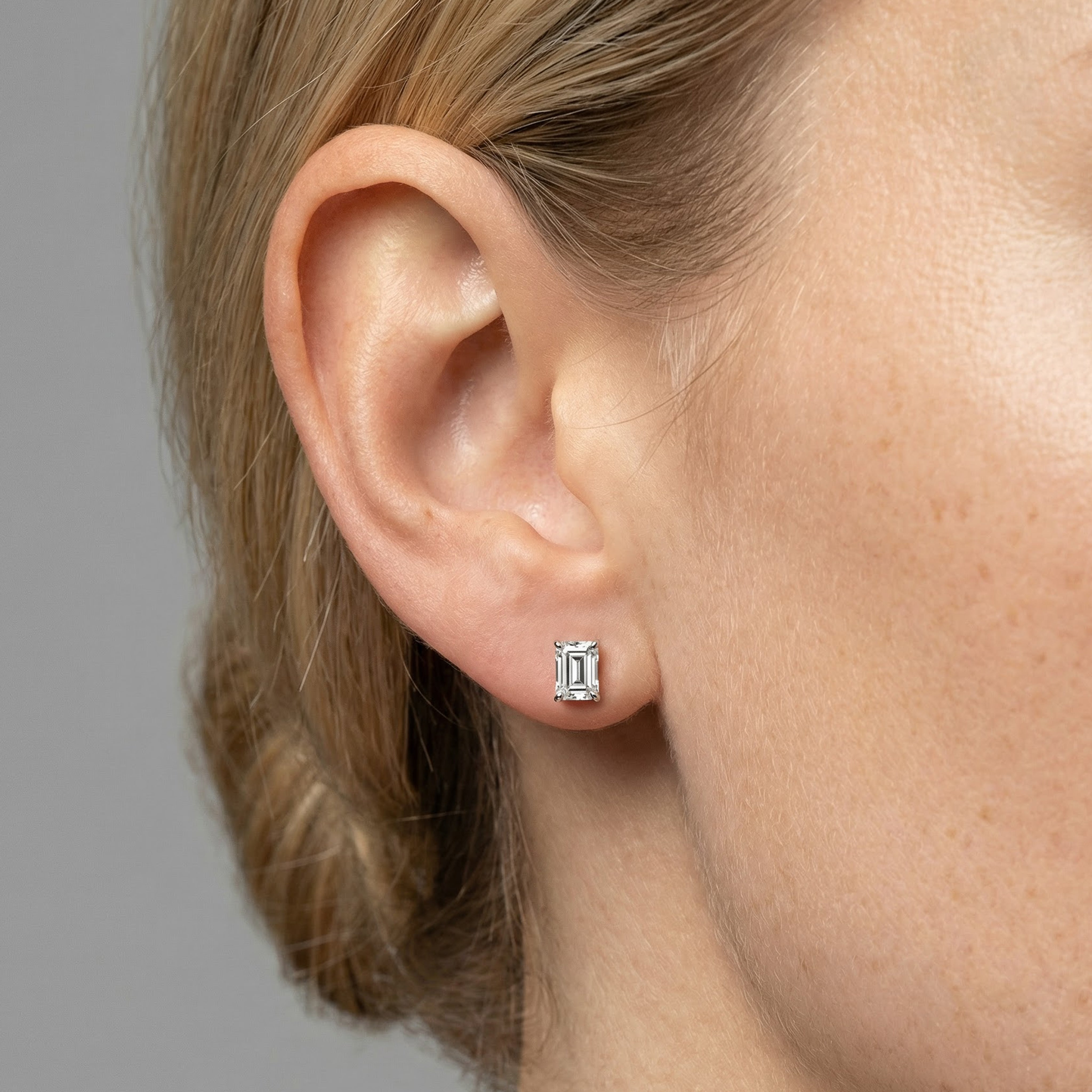 1.5 carat emerald lab grown diamond stud earring in 14k white gold on ear by Michael Gabriels