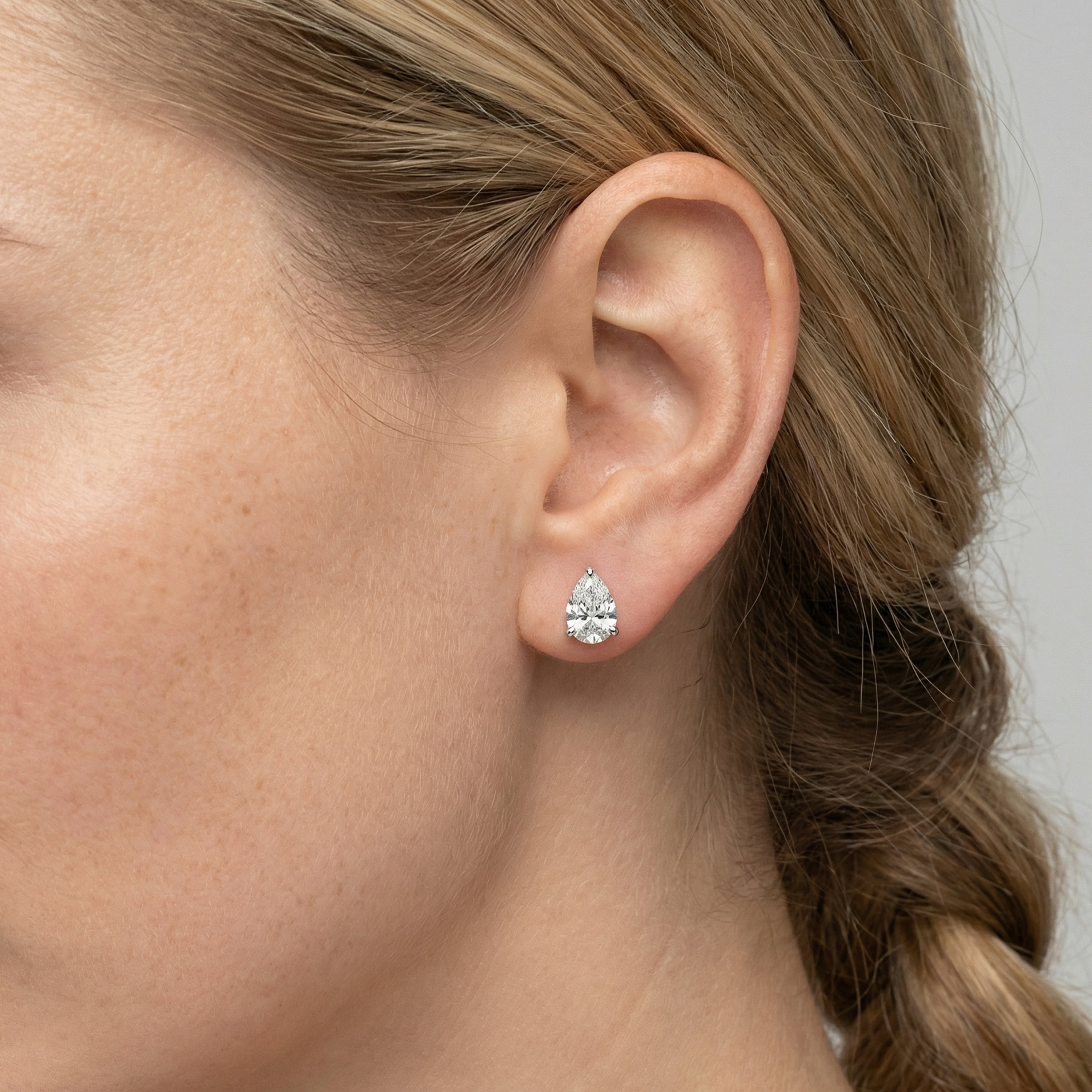1.5 carat pear lab grown diamond stud earring in 14k white gold on ear by Michael Gabriels