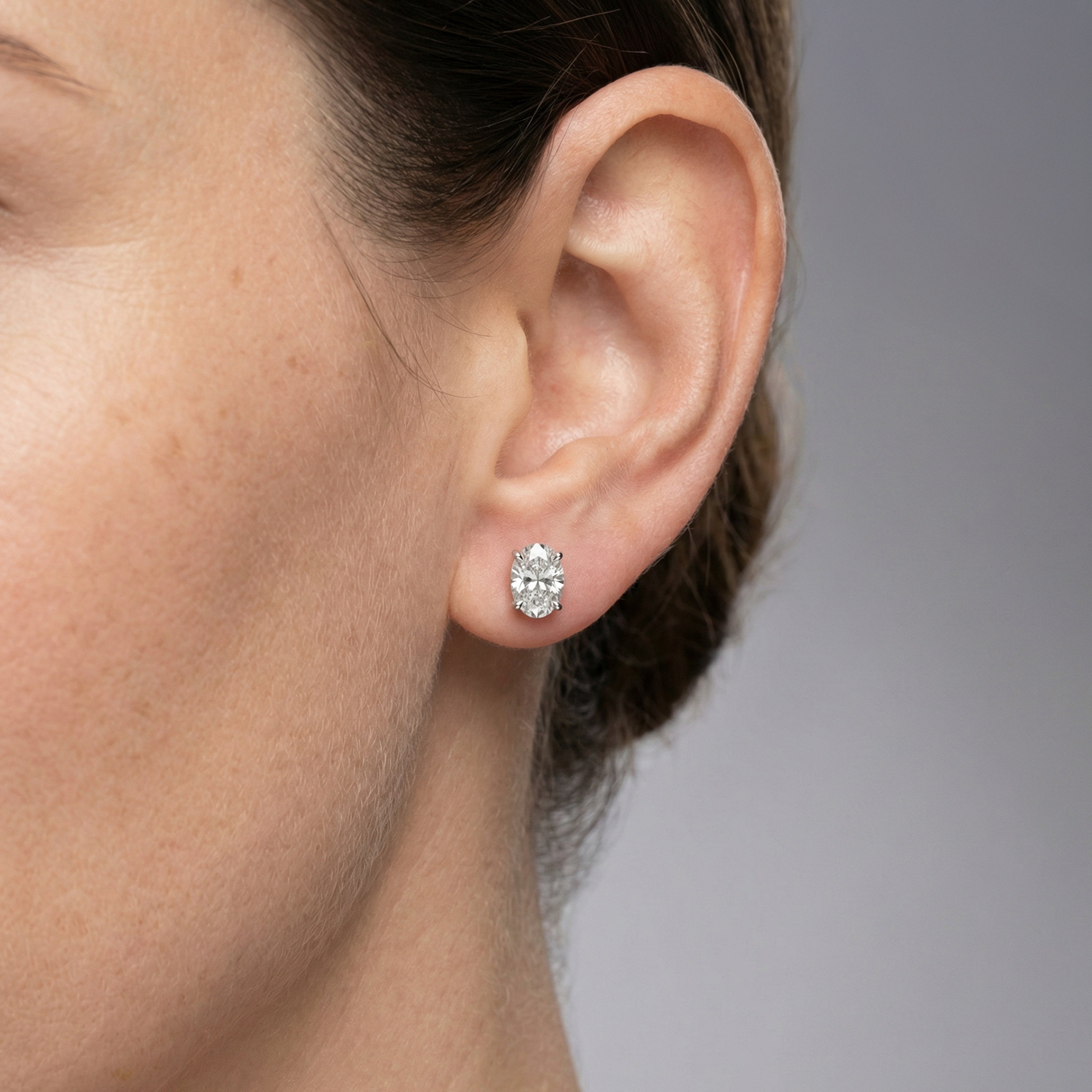 2 carat oval lab grown diamond stud earring in 14k white gold on ear by Michael Gabriels