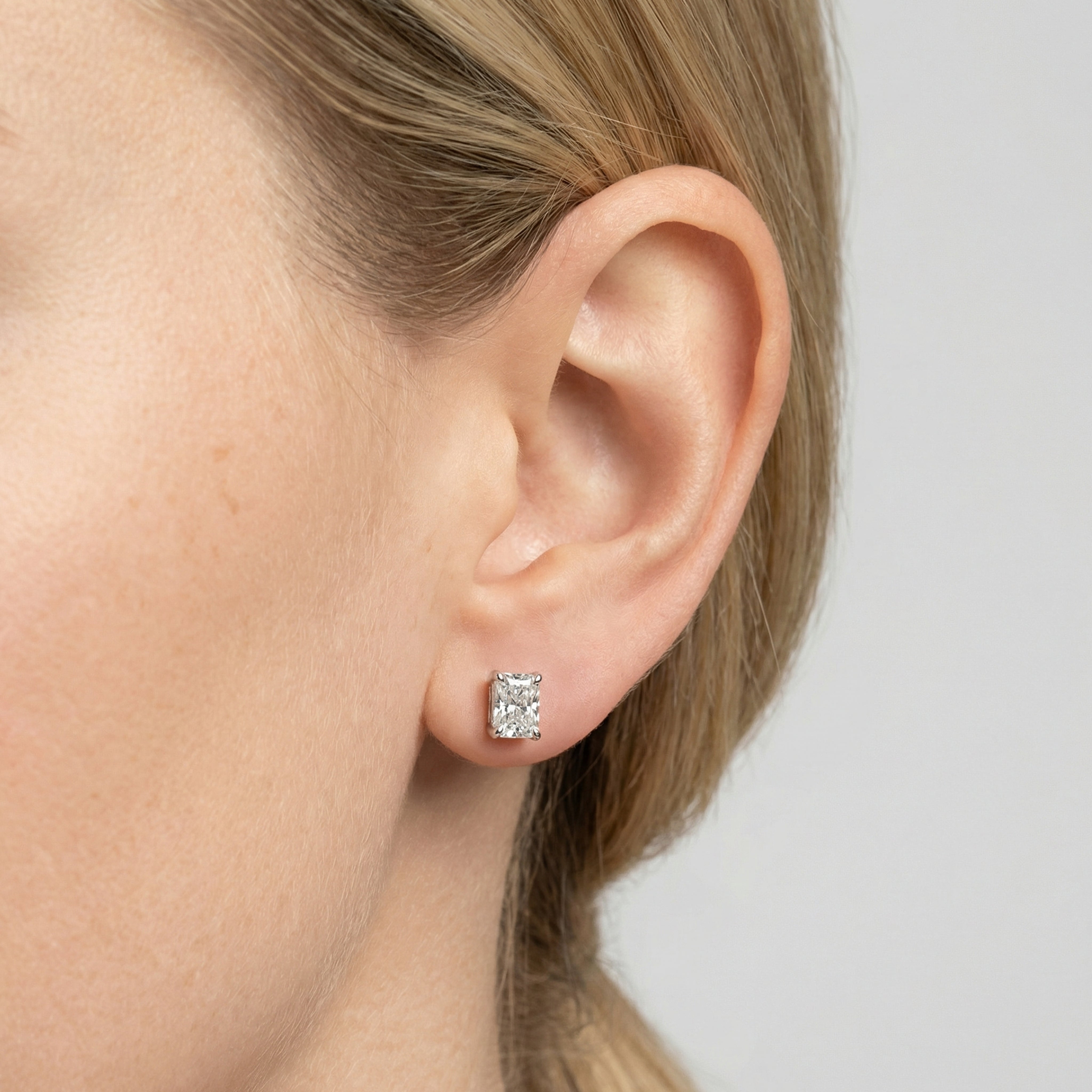 2 carat radiant lab grown diamond stud earring in 14k white gold on ear by Michael Gabriels