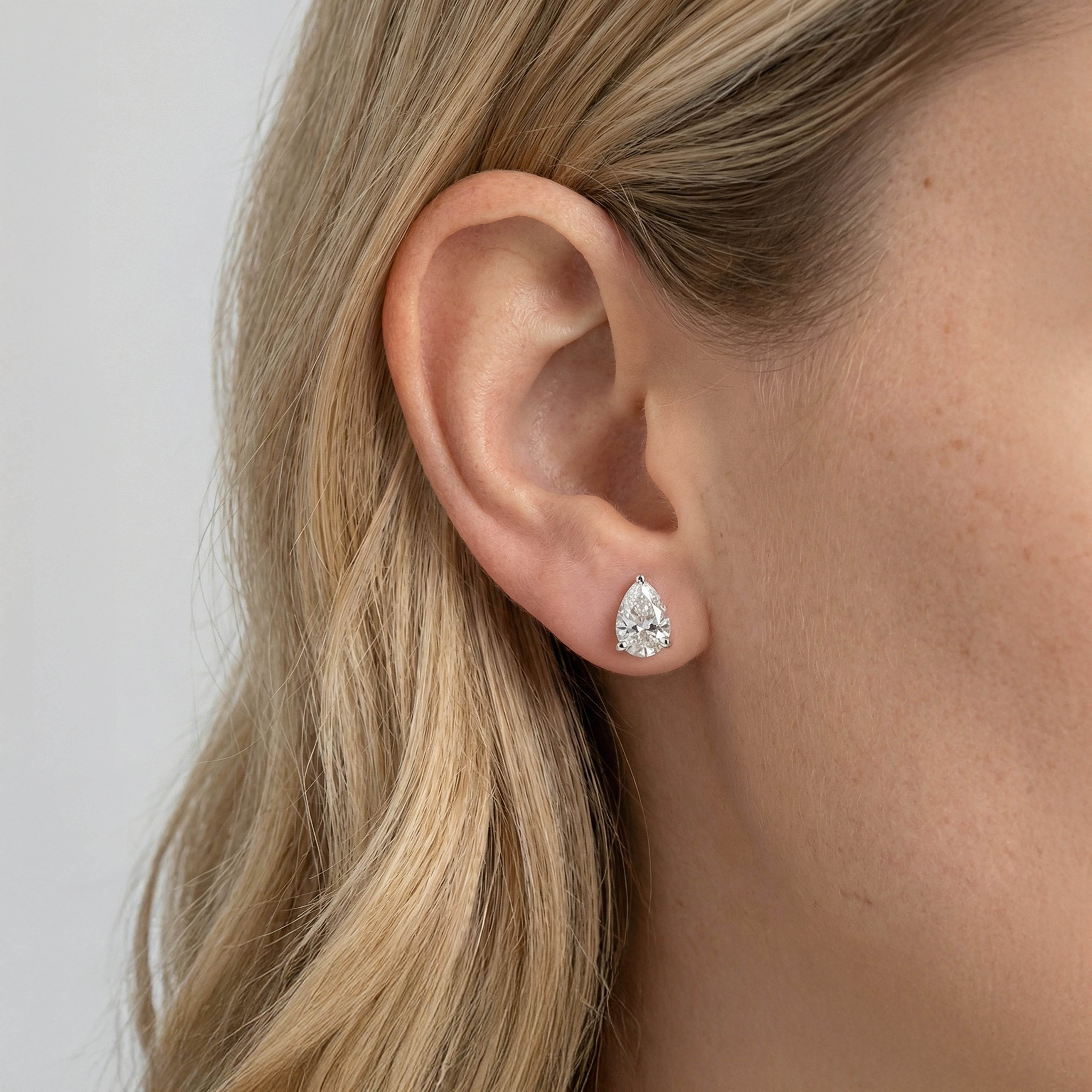 3 carat pear lab grown diamond stud earring in 14k white gold on ear by Michael Gabriels