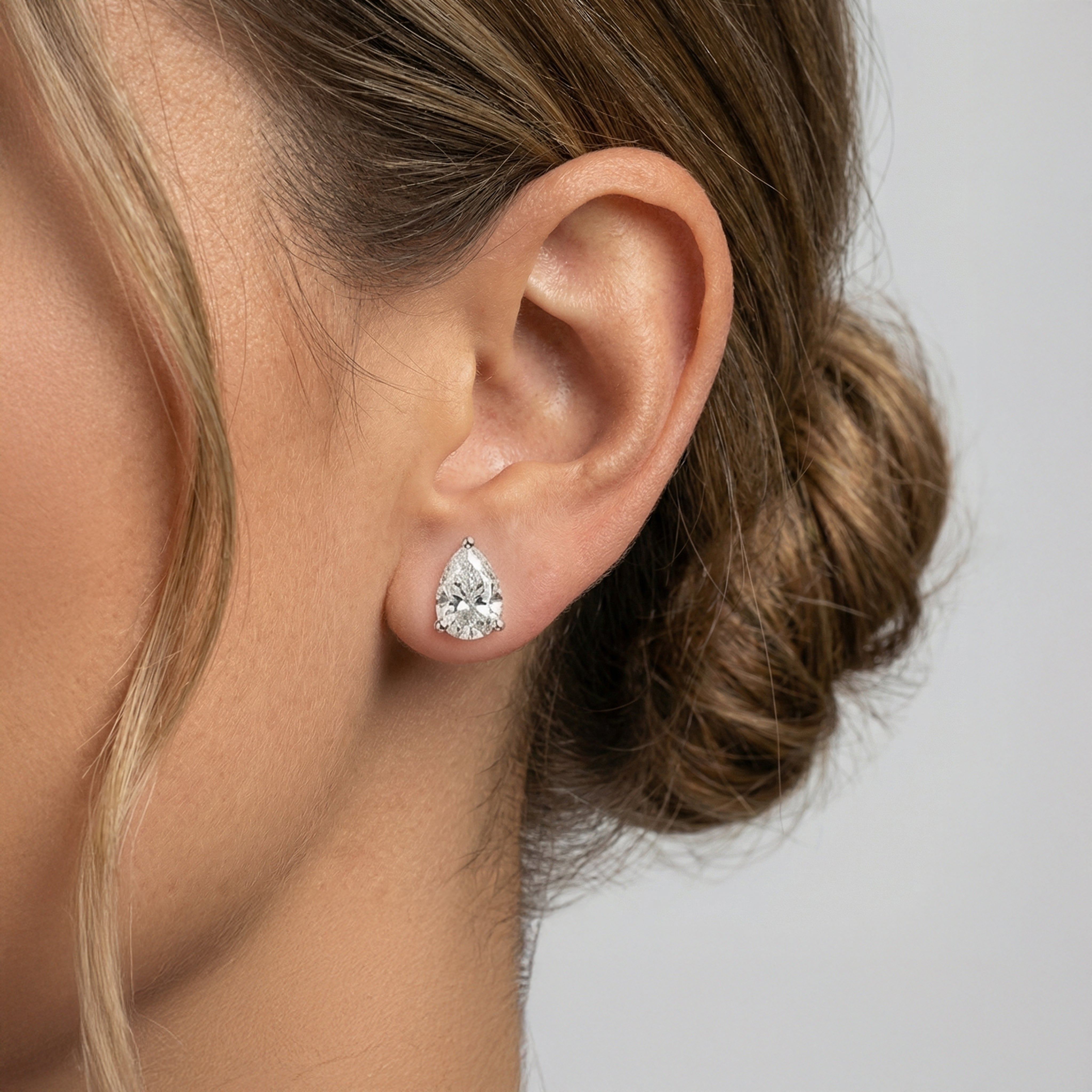 4 carat pear lab grown diamond stud earring in 14k white gold on ear by Michael Gabriels