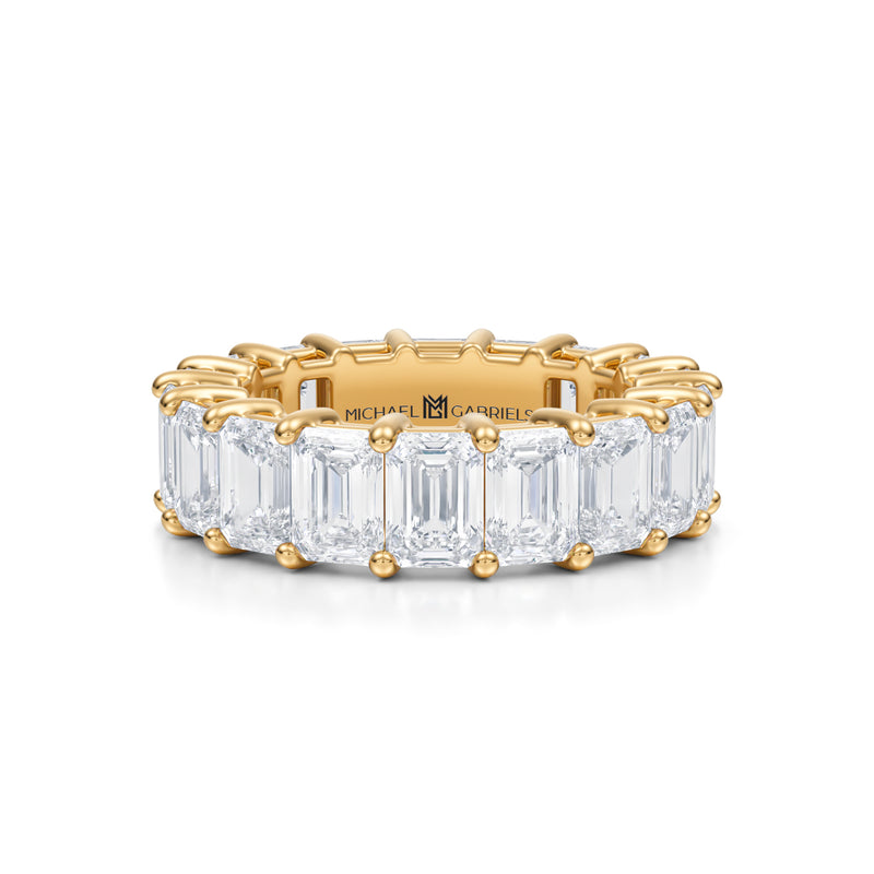 Gold eternity band with lab-grown emerald diamonds.