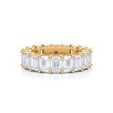 Gold eternity band with emerald lab-grown diamonds.