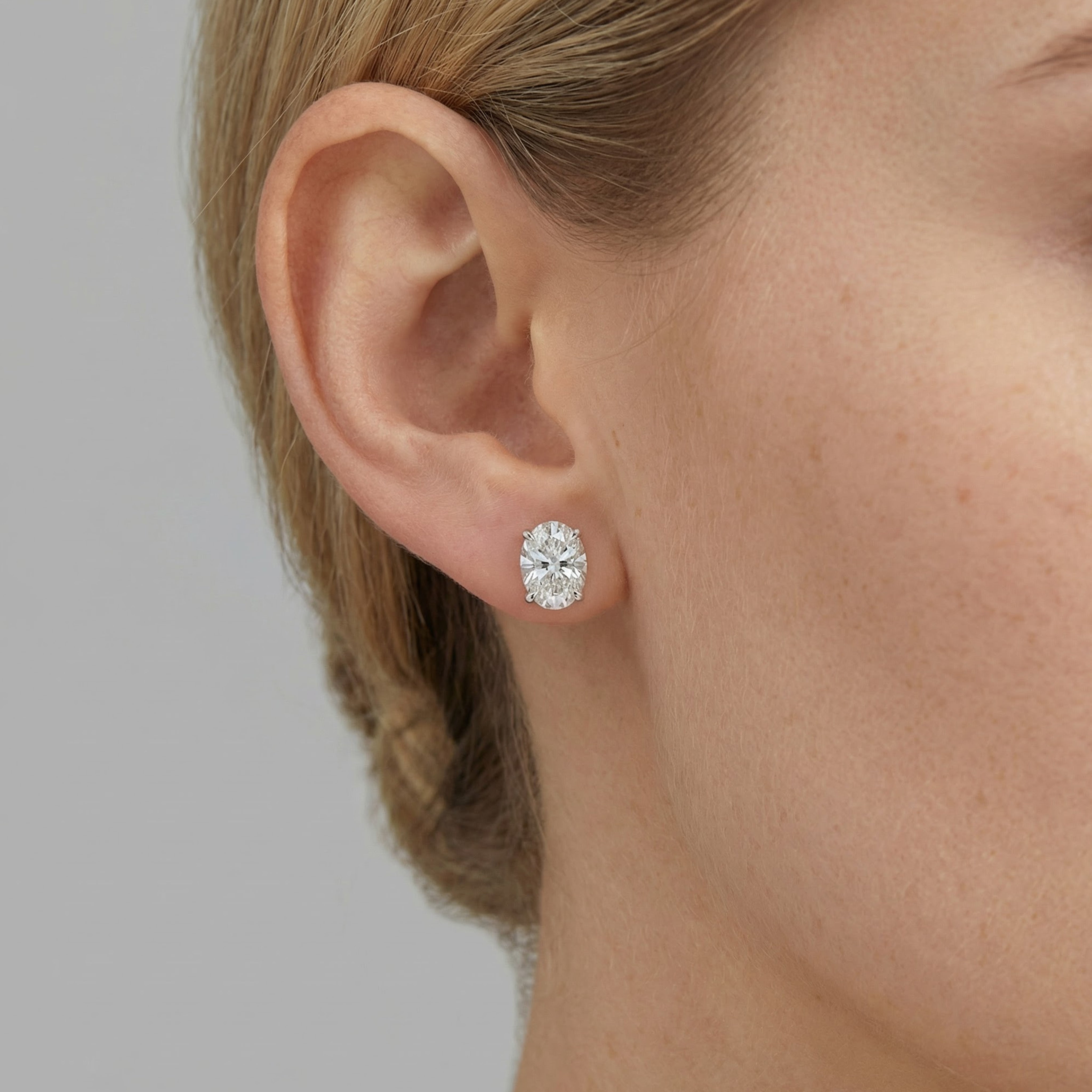 4 carat oval lab grown diamond stud earring in 14k white gold on ear by Michael Gabriels
