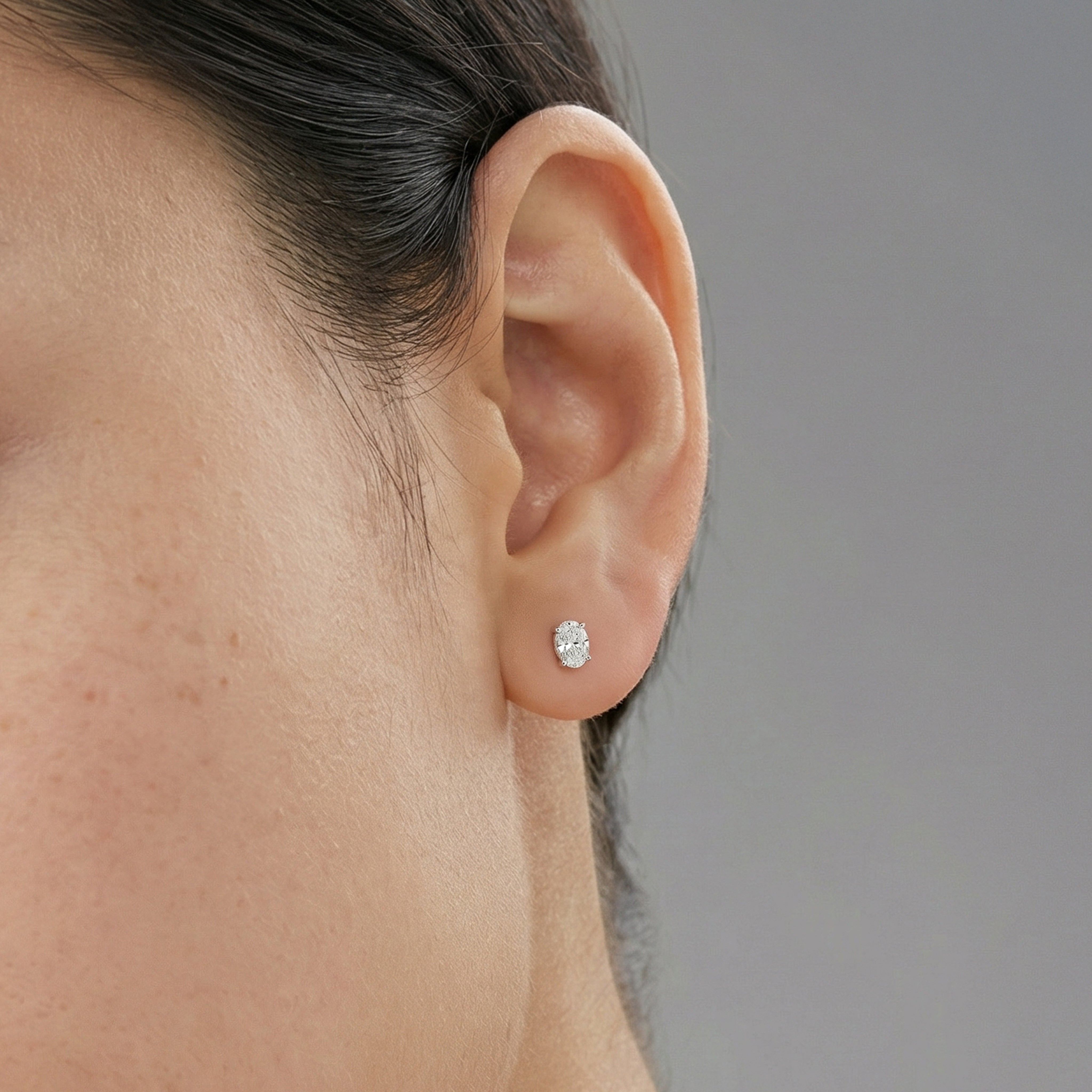 .5 carat oval lab grown diamond stud earring in 14k white gold on ear by Michael Gabriels