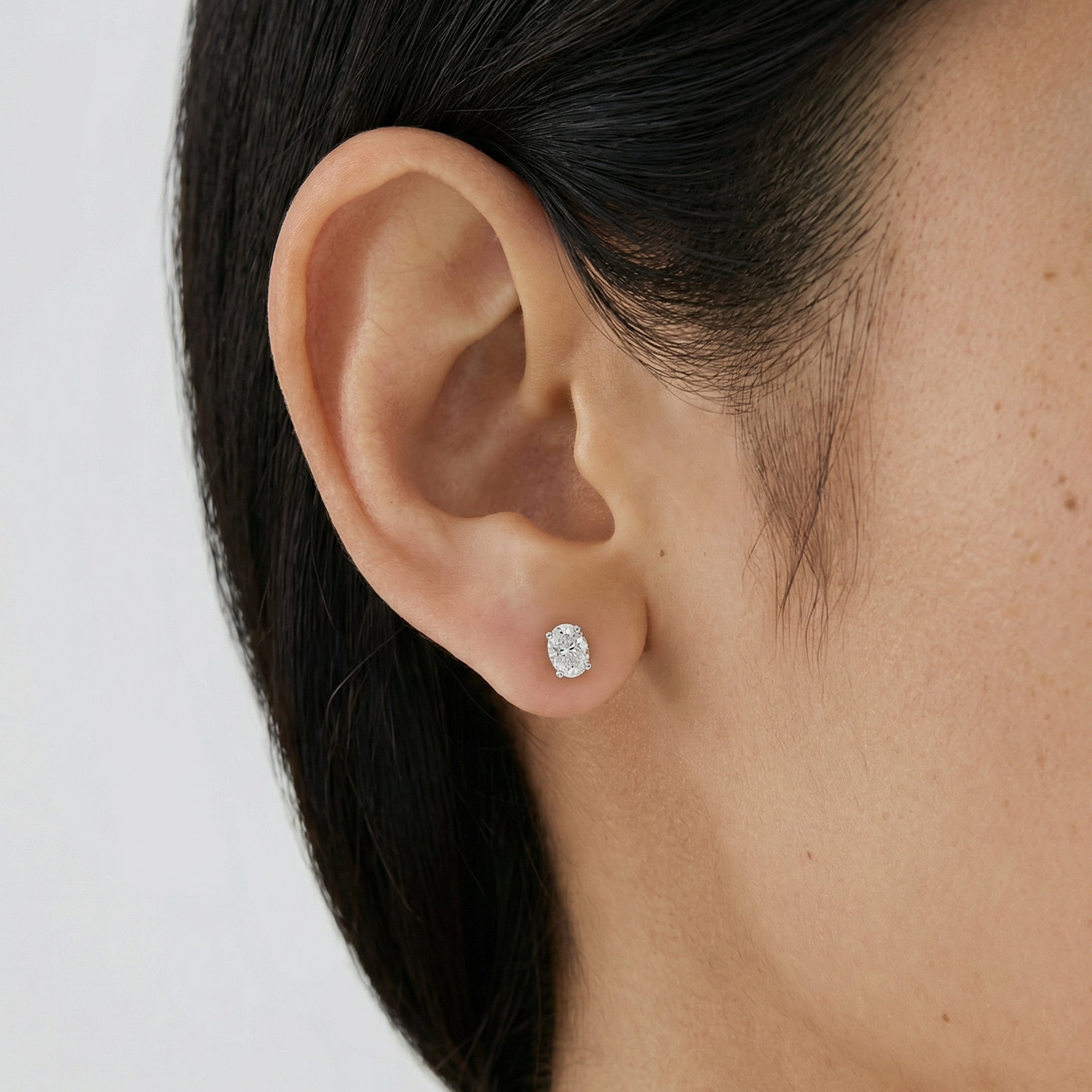 .75 carat oval lab grown diamond stud earring in 14k white gold on ear by Michael Gabriels