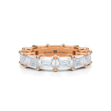 Rose gold eternity band with emerald lab-grown diamonds.