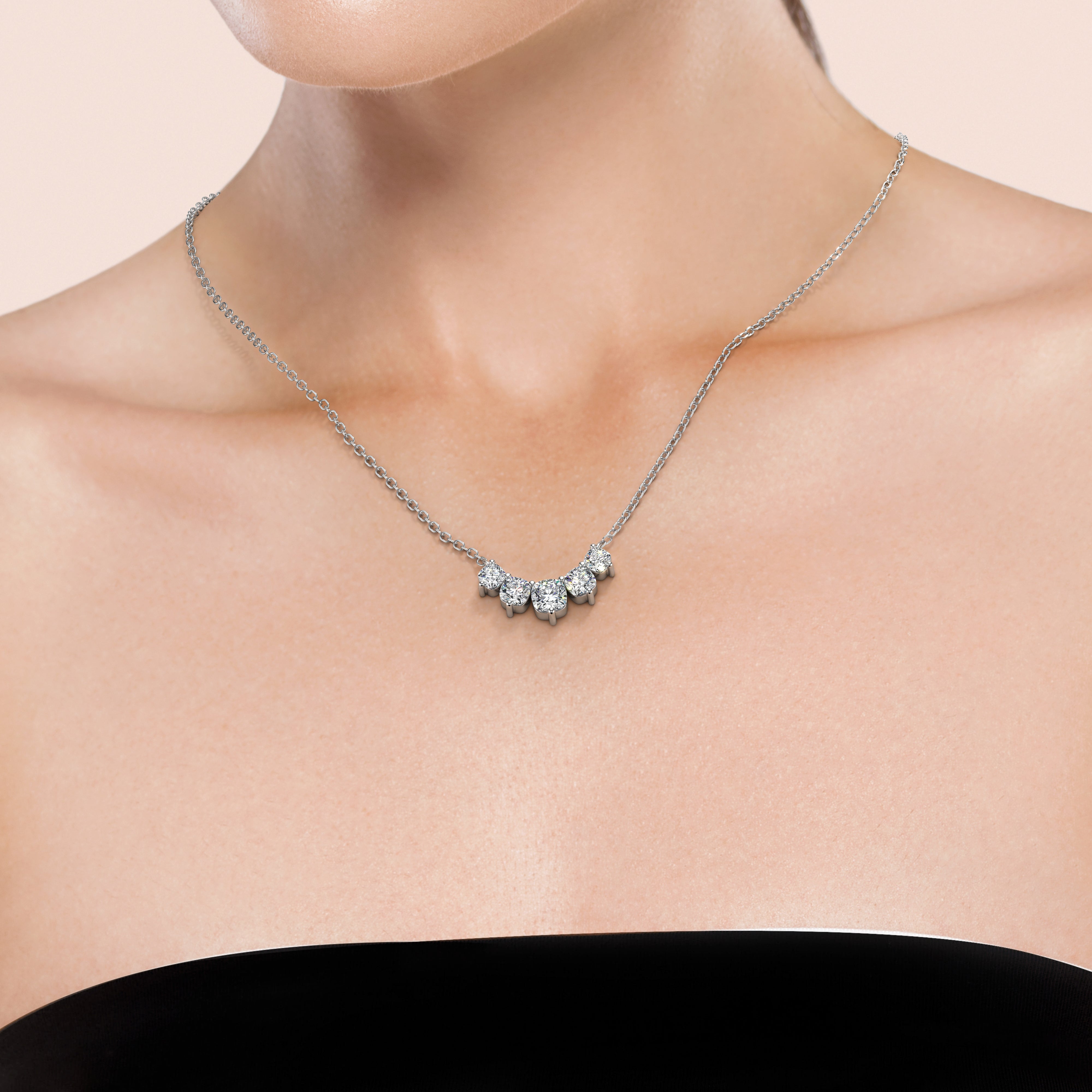 Indulge in a 2 TCW graduated cushion 
lab grown diamond necklace, worn by woman