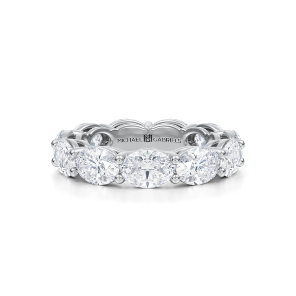 White gold eternity band with oval lab-grown diamonds.