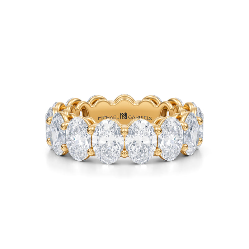 Yellow gold eternity band with lab-grown diamonds in vertical oval shape.