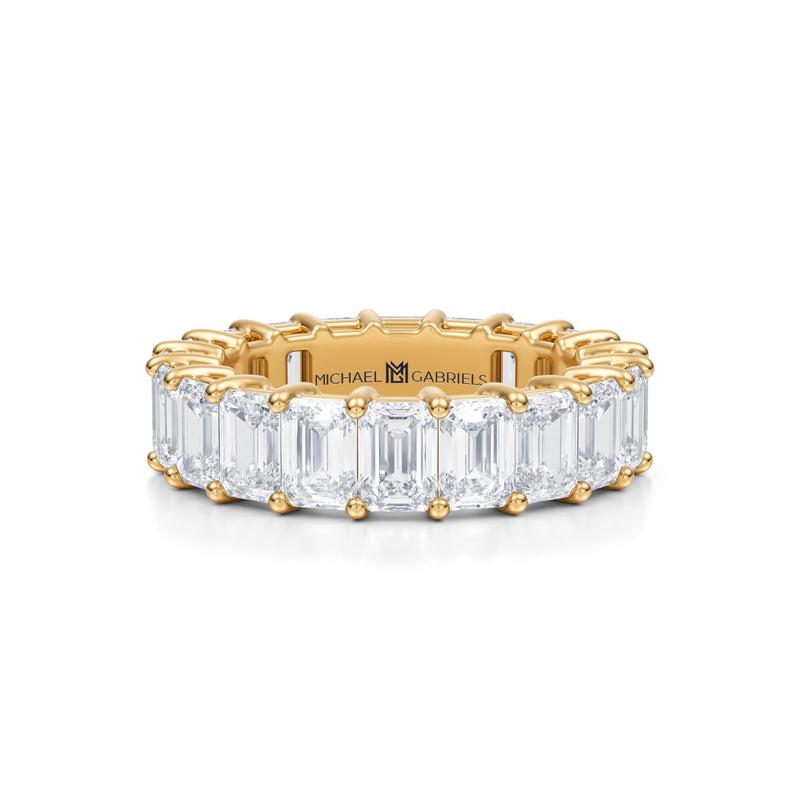 Gold eternity band with emerald lab-grown diamonds.