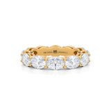 Yellow gold eternity band with lab-grown diamonds in oval shape.