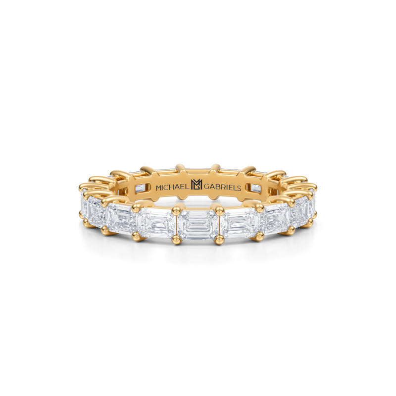 Petite eternity band with lab-grown emerald diamonds in yellow gold.