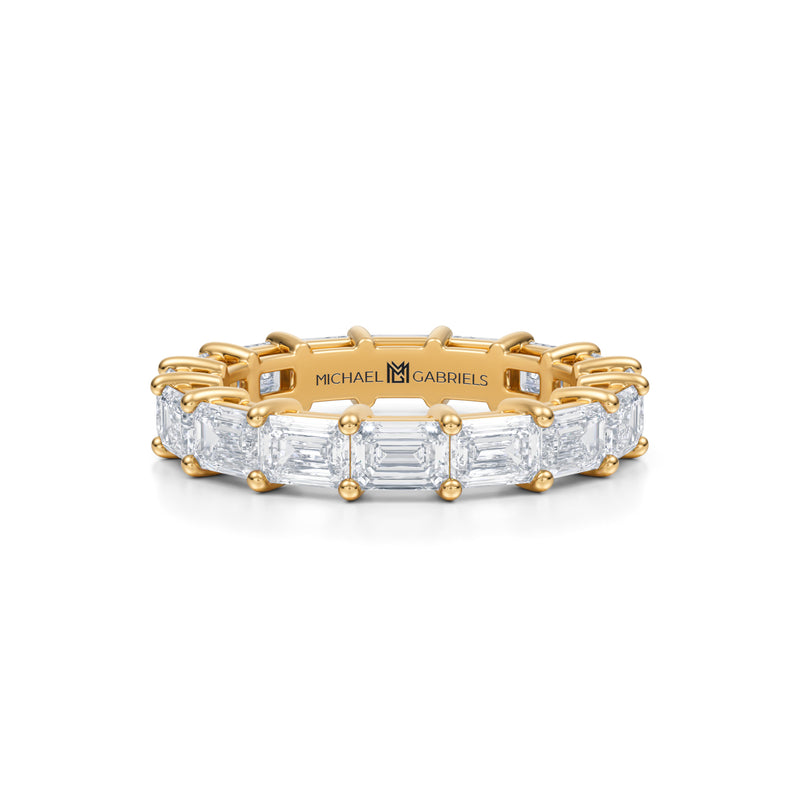 Yellow gold eternity band with emerald lab-grown diamonds.